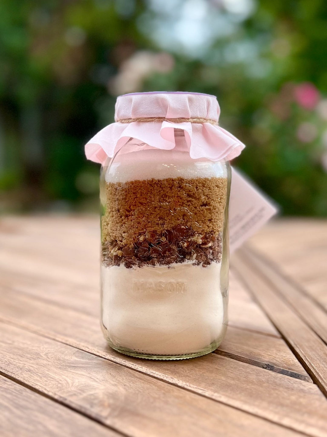 The image shows the back of a Cookie Mix Jar by Turtle Tracks, to show the layers of yummy ingredients.